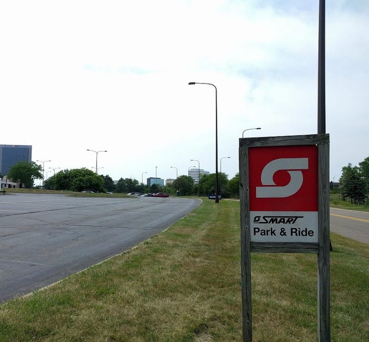 A wooden red and white sign with the SMART logo marks the Troy Civic Center Park and Ride Lot.