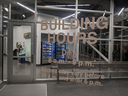 A door labeled "Building Hours: Daily, 8am to 9pm. Access may vary before 10am and after 6pm."