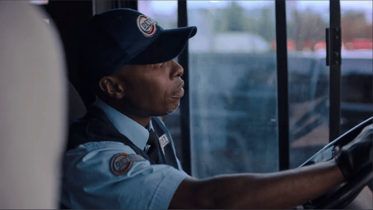 The bus driver in the show wearing a uniform with a circular red Detroit patch