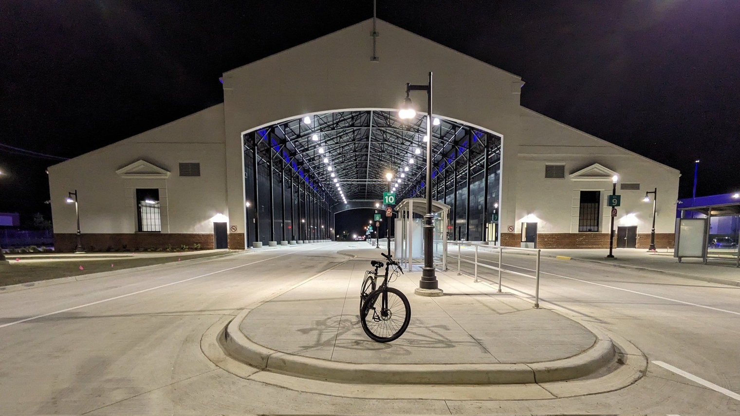 My bike in front of Jason Hargrove Transit Center's south portico at night, next to the shelter for Bay 10