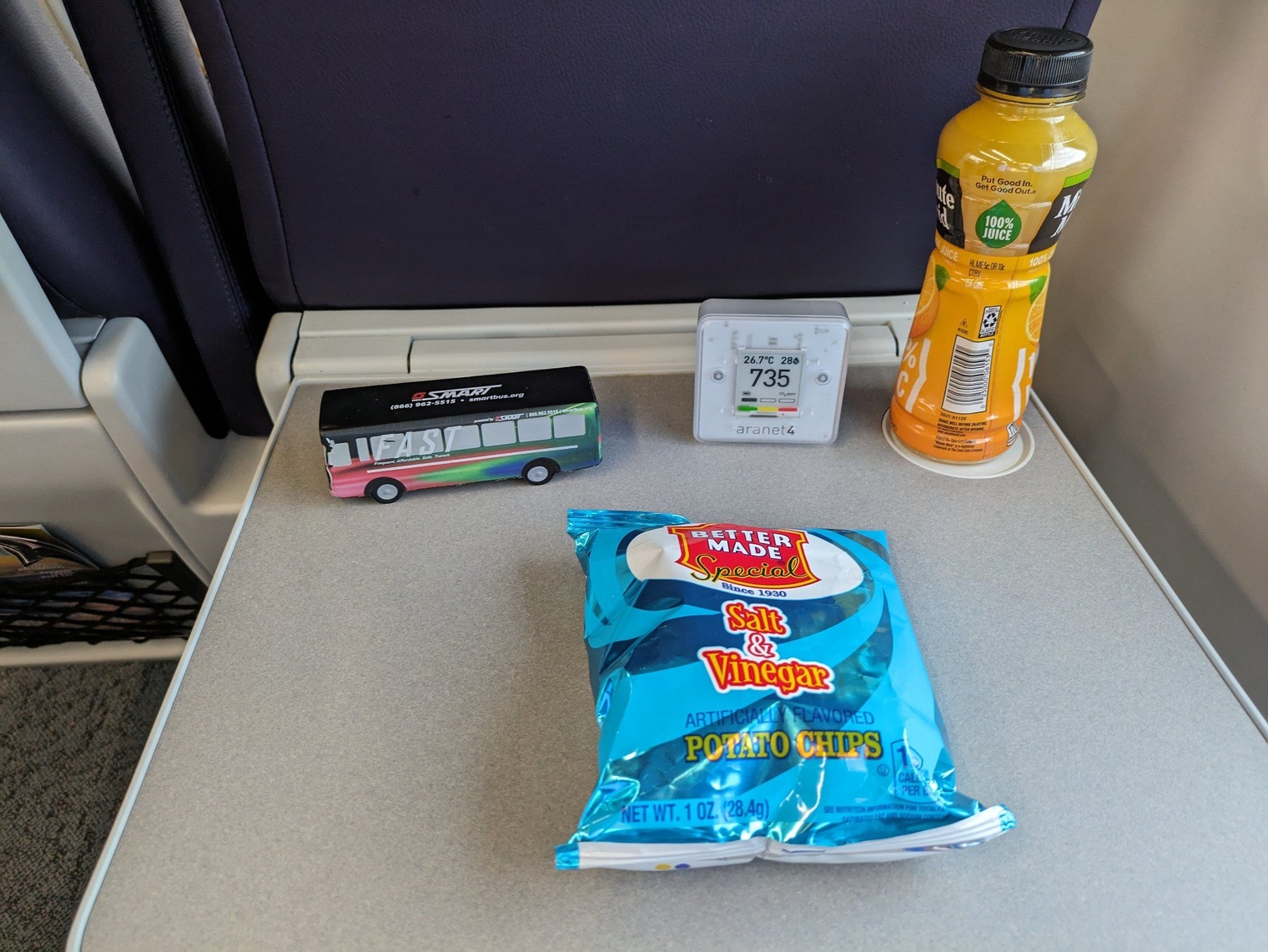 Chips and an orange juice from the café car. My squishy bus and Aranet are also on the tray table