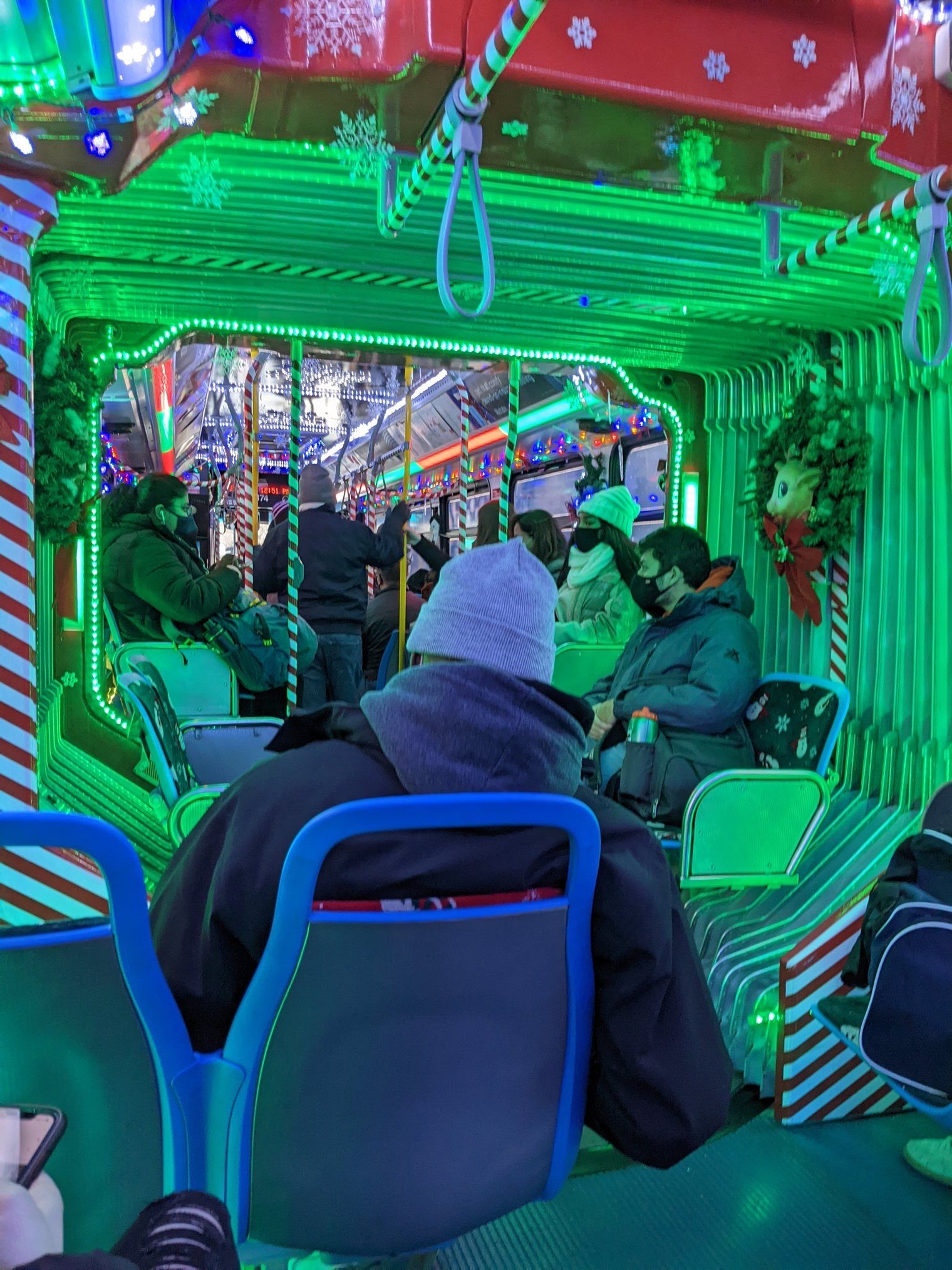 Red and green interior of the Holiday Bus with the poles decorated to look like candy canes