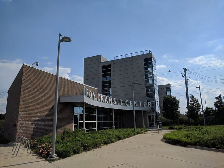 The Troy Transit Center, a modern two-level station with a pedestrian bridge over the tracks.