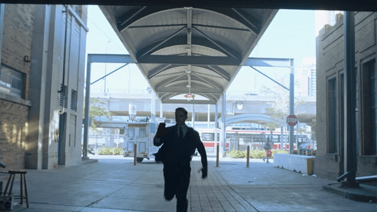 A hunter running down a walkway with a bus in the background