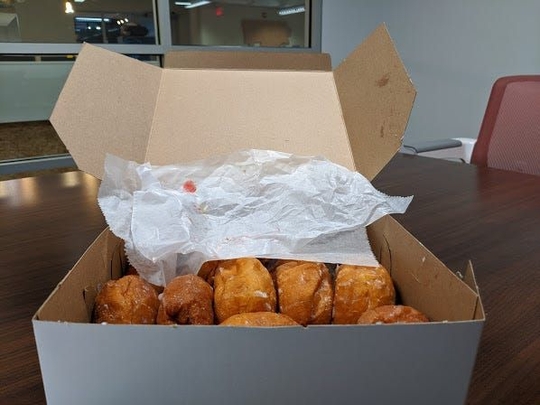 The freshly opened box of paczki sitting on a desk in TechTown