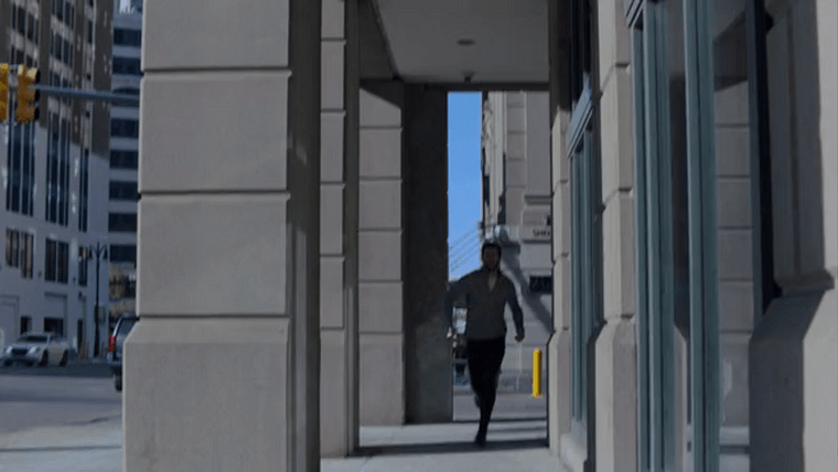 Dodge running underneath concrete pillars along a street