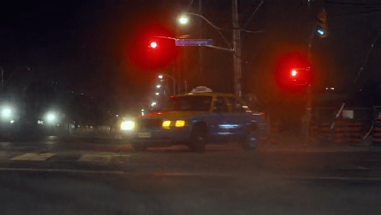 A taxi swerving through an intersection at night