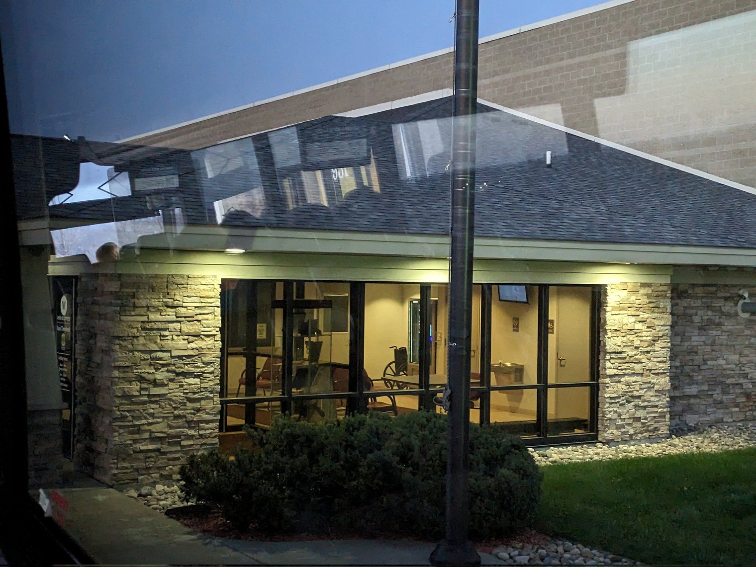 The inside of the station waiting area as seen from the bus, with a ticket window and restrooms