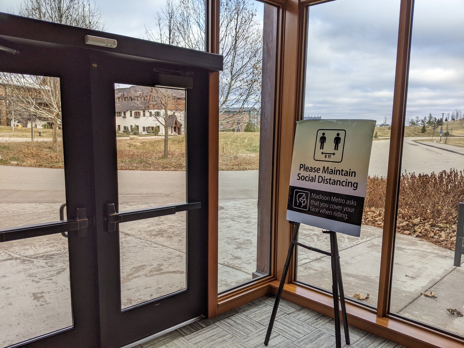 Door to the bus with a sign reminding riders masks are required on Madison Metro