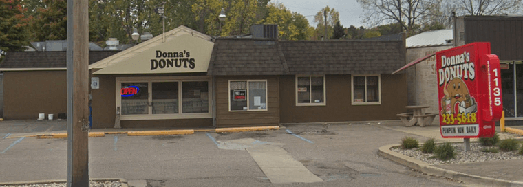 Brown vinyl shop with a red sign shaped like a coffee mug