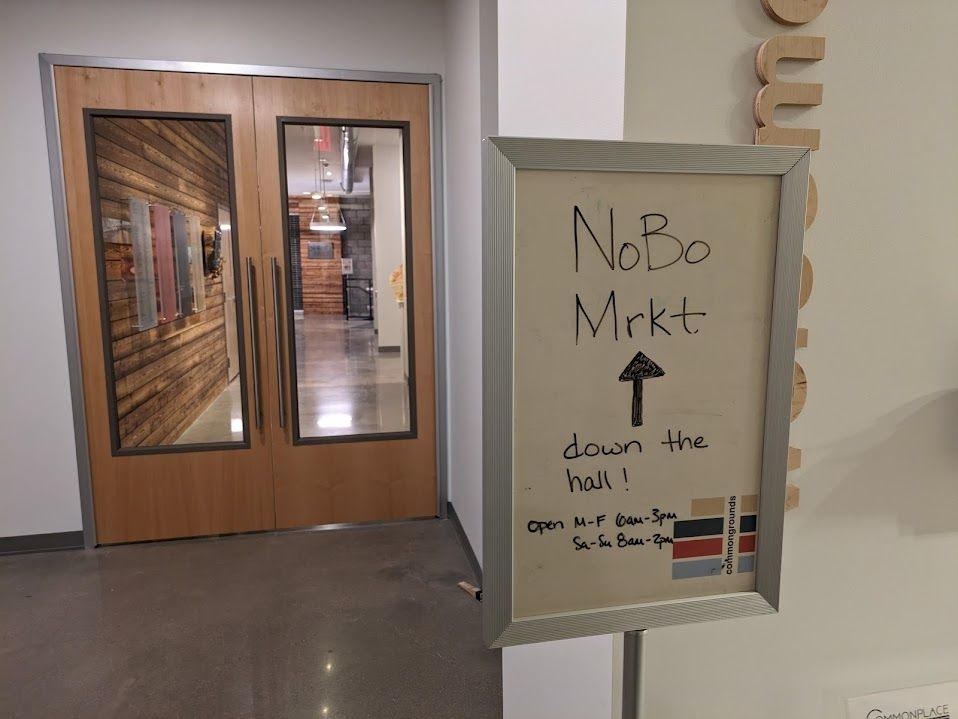 A sign inside the main entryway directing visitors to NoBo Market, the coffee shop and food hall.