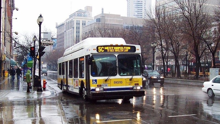 A photo of a real bus in downtown Hamilton with a yellow stripe