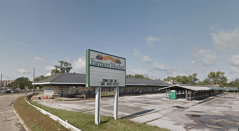 The now-abandoned Flint Farmers' Market site sign reads "Come see us at 300 East 1st Street"