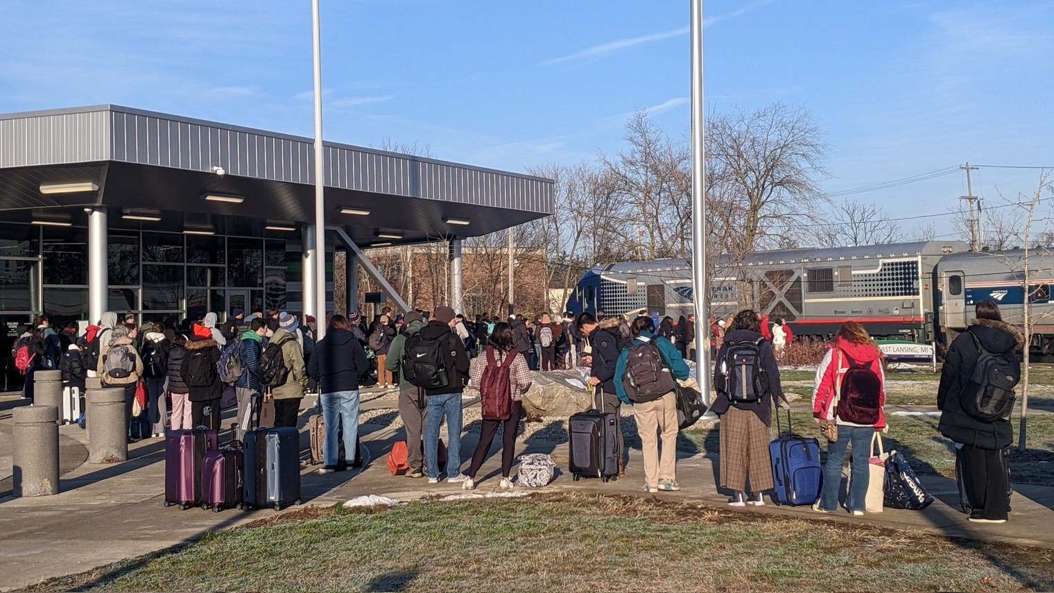 A crowd of at least 50 students in line to board the train to Chicago from East Lansing