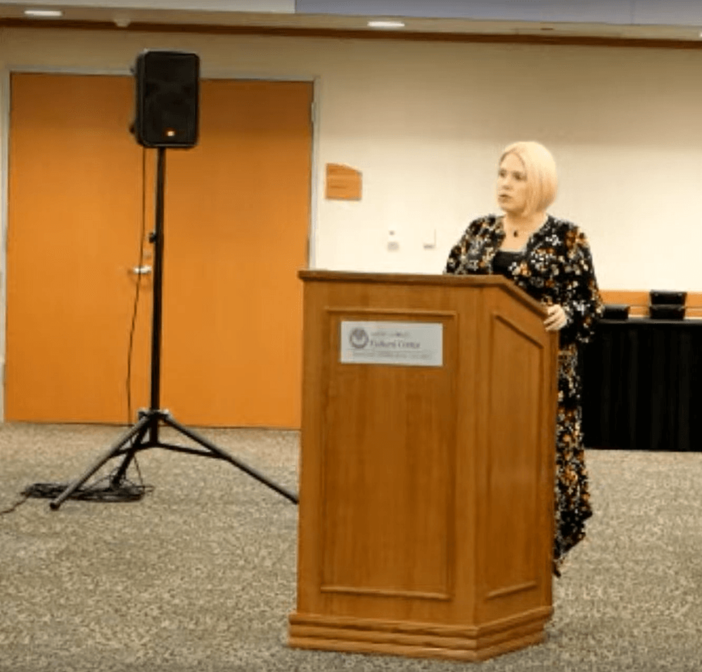 Harmony Lloyd standing behind a lectern at Macomb Community College Central Campus