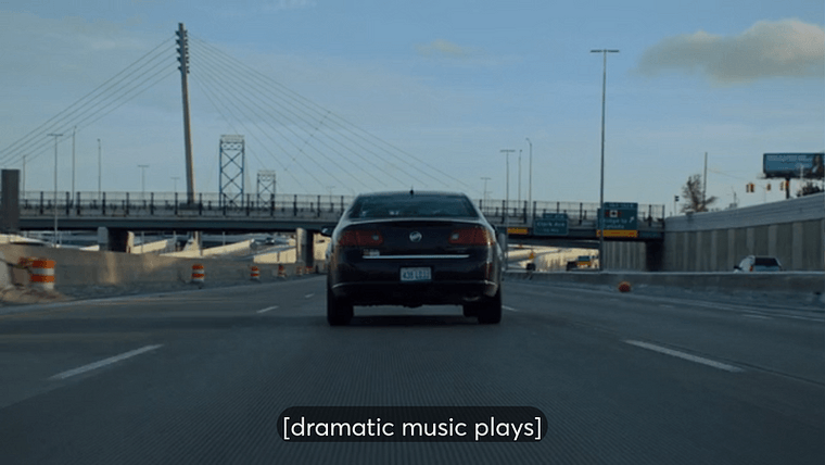 A car on the highway approaching the Ambassador Bridge with the caption “dramatic music plays”