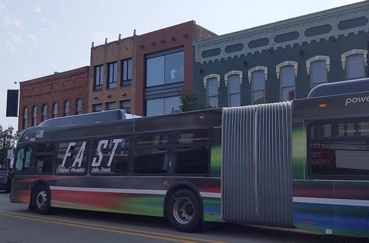 An articulated FAST Woodward bus travels south on Saginaw Street.