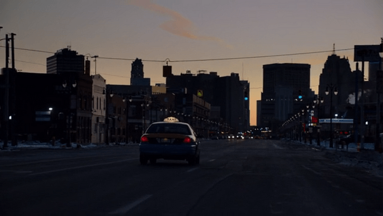 A taxi headed eastbound on Michigan Avenue towards downtown at twilight