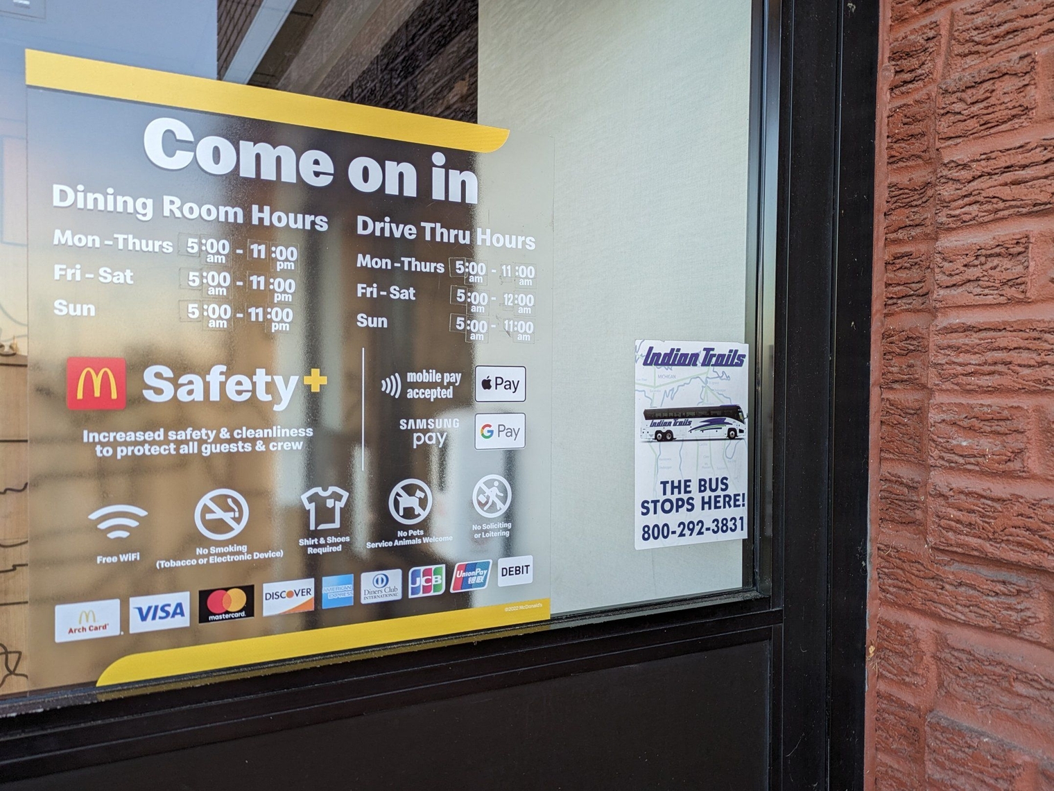 Sticker on the McDonald's door says "Indian Trails: The Bus Stops Here!" with a picture of a bus on it