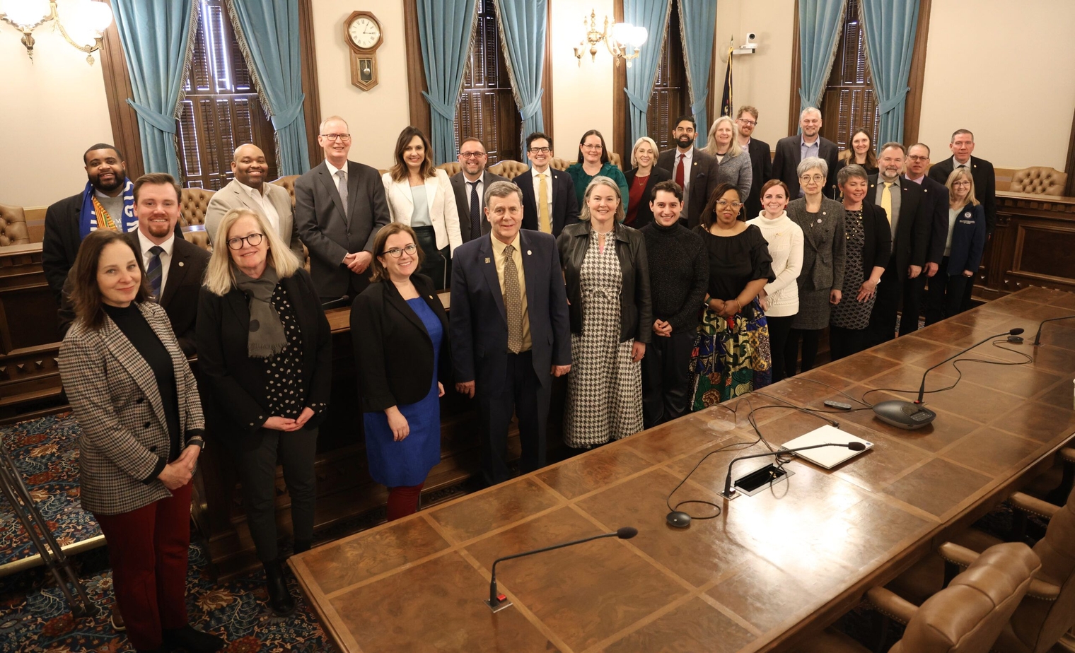 Members of the Public Transit Caucus meet for the first time on Feb. 28, 2024, stand behind the meeting table in the House Appropriations room inside the Michigan State Capitol.