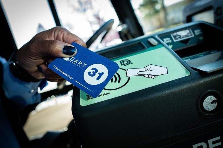 A DDOT driver holds a DART pass to a farebox reader in a promotional photo.