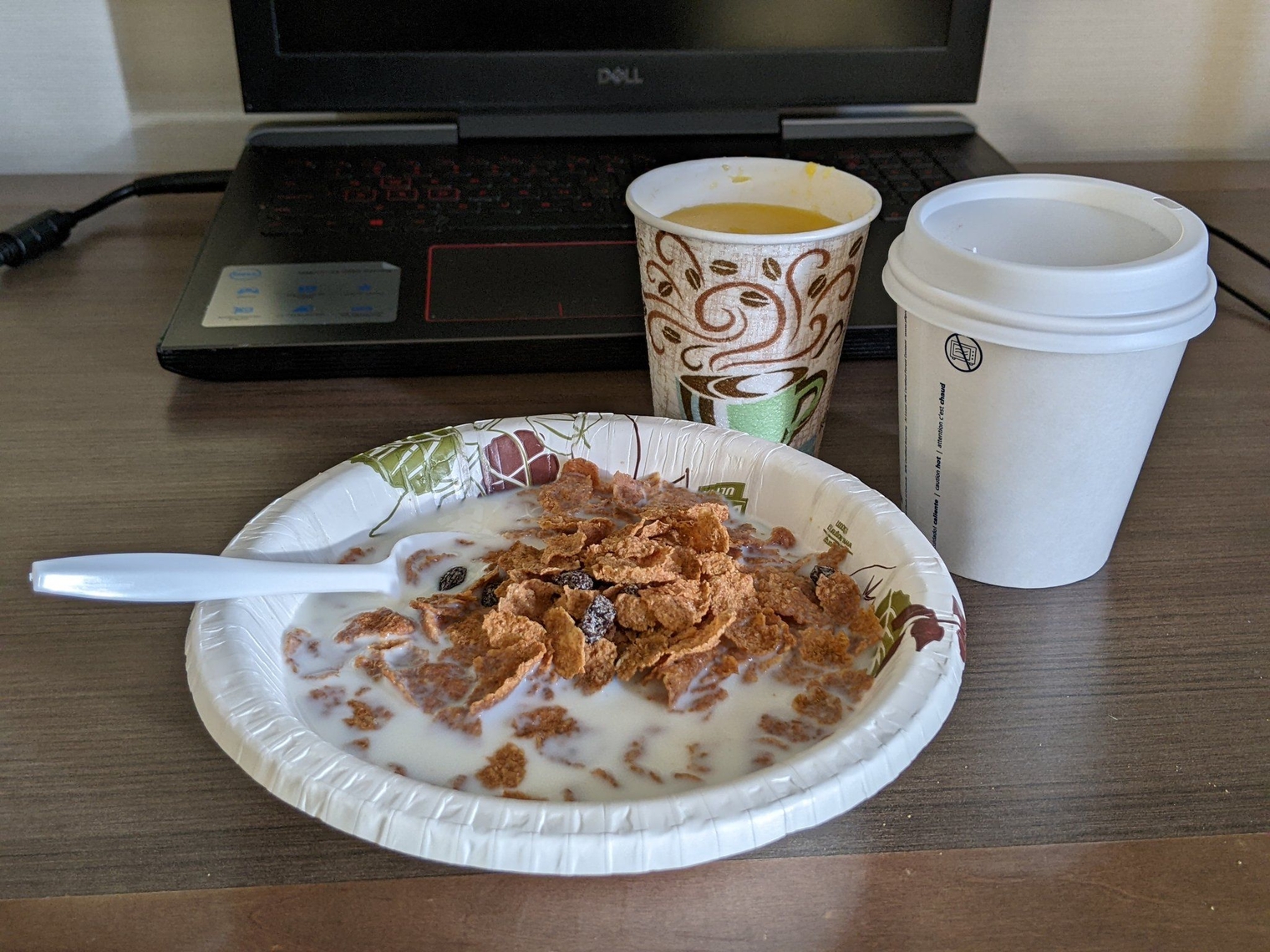 Cereal in a paper bowl with orange juice and coffee