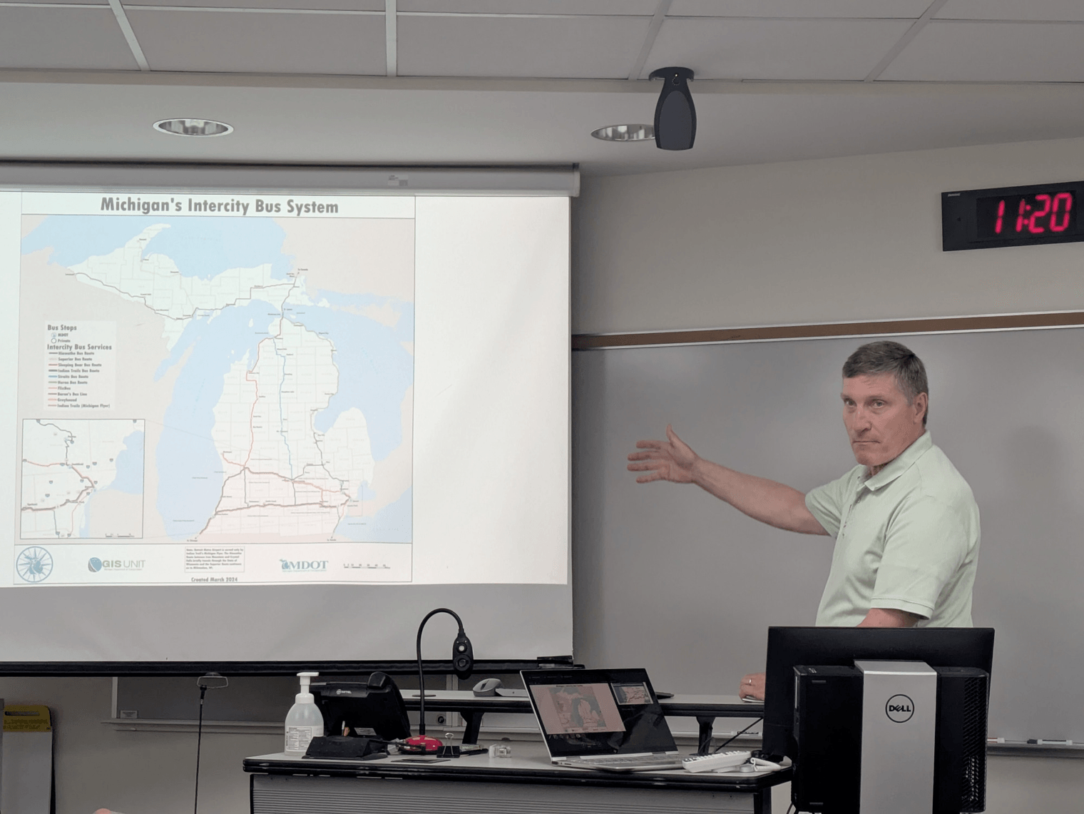 Eric Schertzing gesturing at a map of Michigan on a projector slide