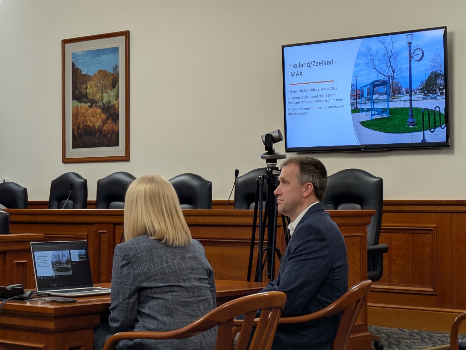 Harmony Lloyd and John Dulmes present a slideshow emphasizing the importance of fully funded local bus operating assistance. A snapshot of Holland/Zeeland MAX service is onscreen.