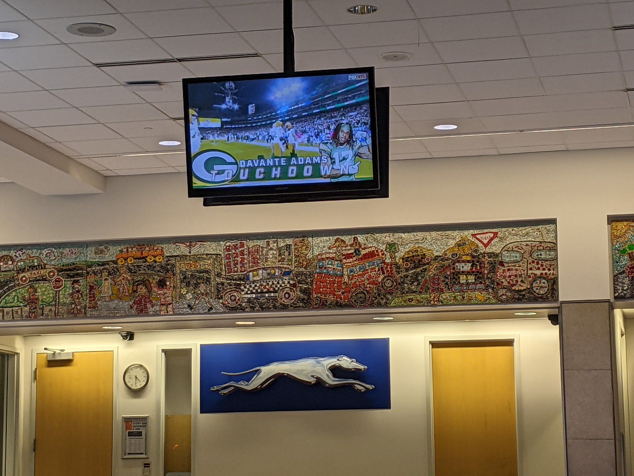 The Green Bay Packers score a touchdown on TV inside the train station