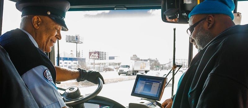 A real bus driver smiling warmly at a boarding passenger