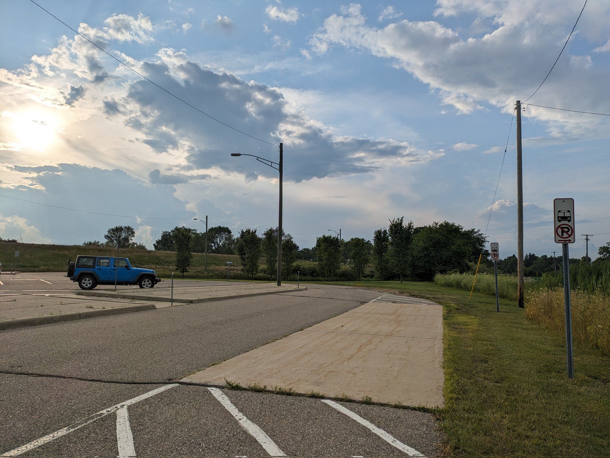 A bus lane on the perimeter of the Grand Blanc Township P&R lot marked by generic bus stop signs that say no parking