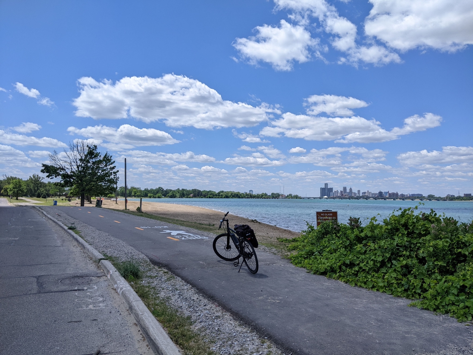 My e-Sparrow on the paved bike path next to the water with the Renaissance Center visible in the distance