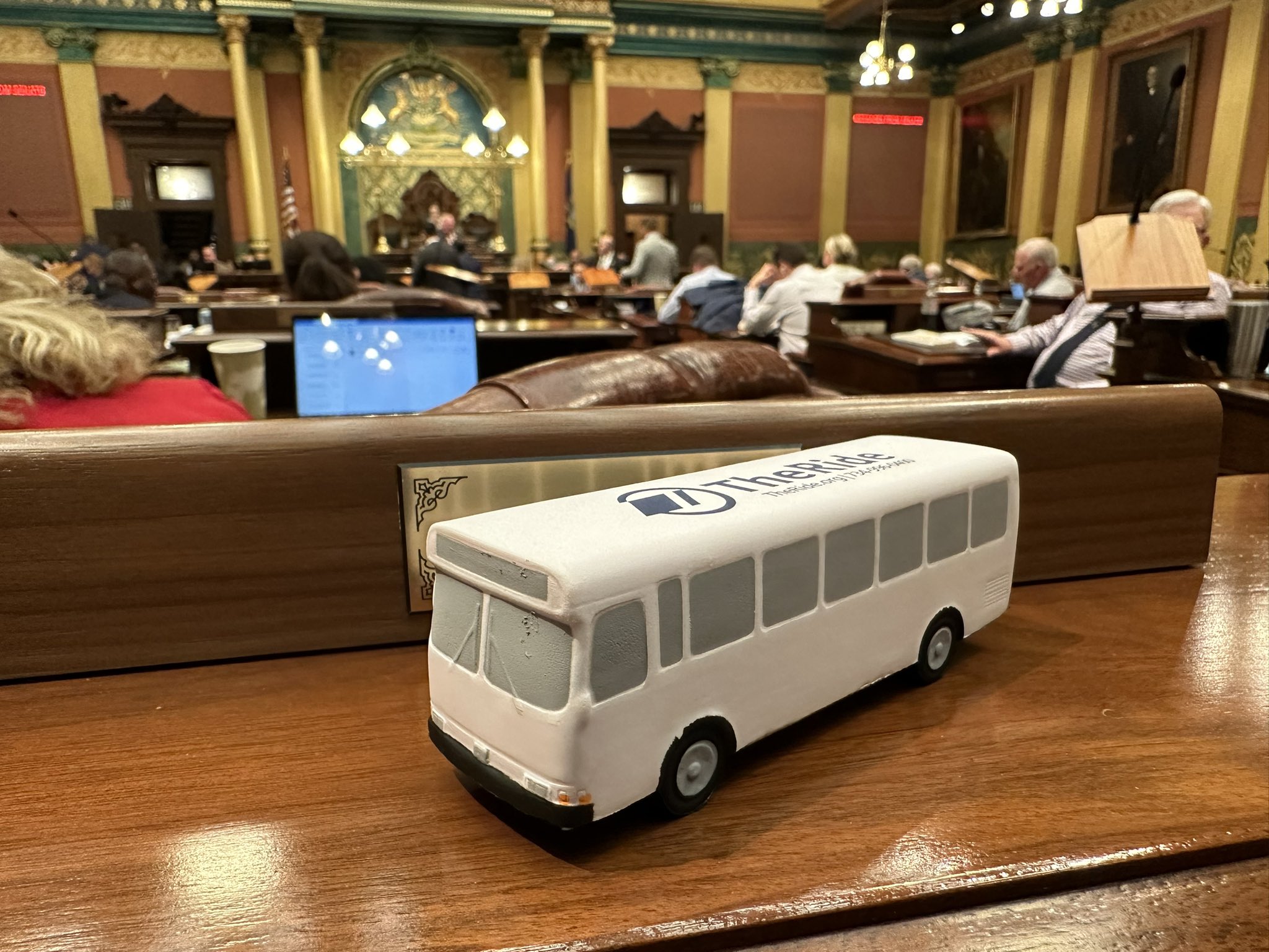 A white squishy bus with the Ann Arbor TheRide logo printed on top on Representative Jason Morgan's desk in the Senate chamber.