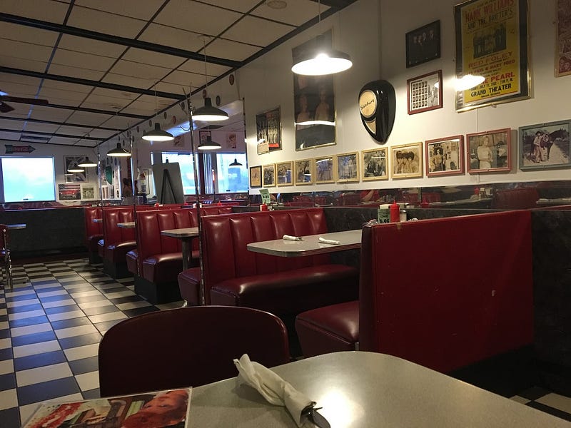 Interior with red booths and 50s memorabilia on the walls