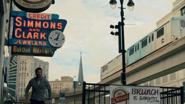 Dodge Tynes, the protagonist of Most Dangerous Game played by Liam Hemsworth, runs underneath the Simmons and Clark Jewelers neon sign downtown as the People Mover passes overhead.