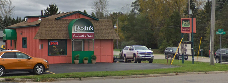 A very small restaurant building. Sign reads "Pesto's, Food with a Flair!"